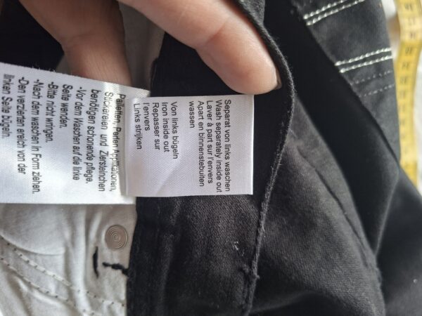 Zwarte flared broek met strass details en witte stiksels