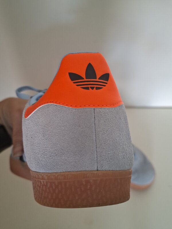 Adidas Gazelle sneakers lichtblauw met zwarte strepen en oranje hielstuk