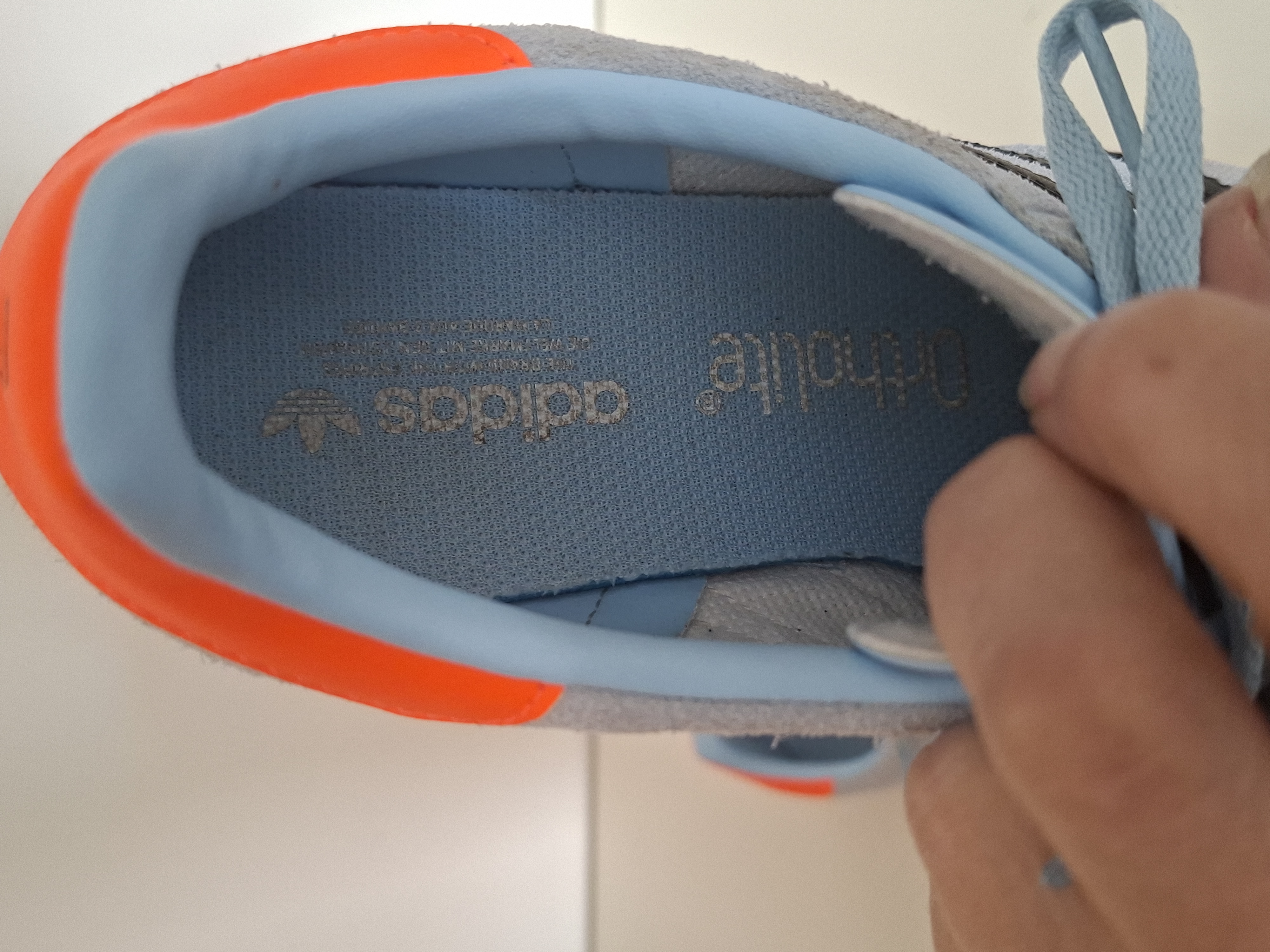 Adidas Gazelle sneakers lichtblauw met zwarte strepen en oranje hielstuk