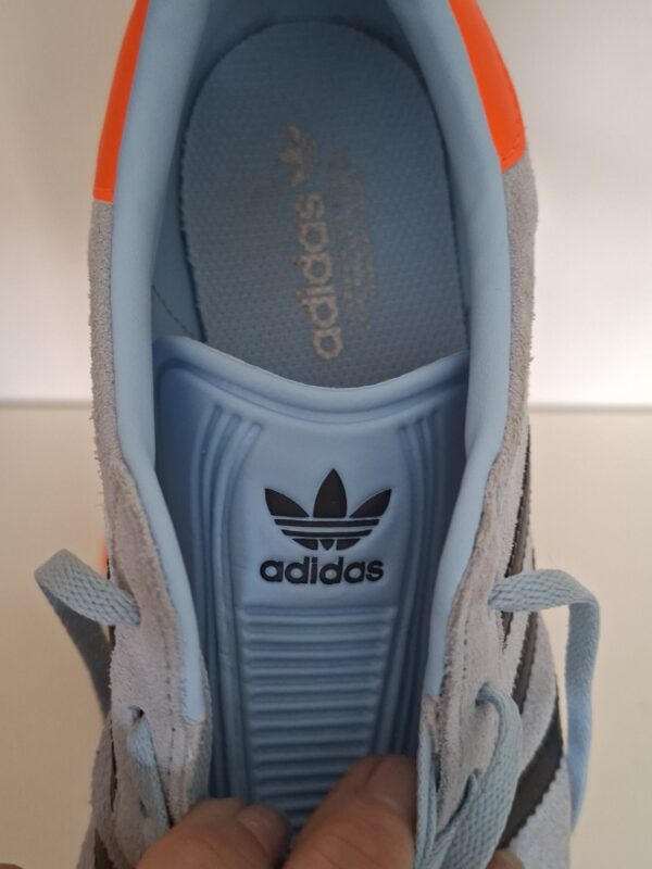 Adidas Gazelle sneakers lichtblauw met zwarte strepen en oranje hielstuk