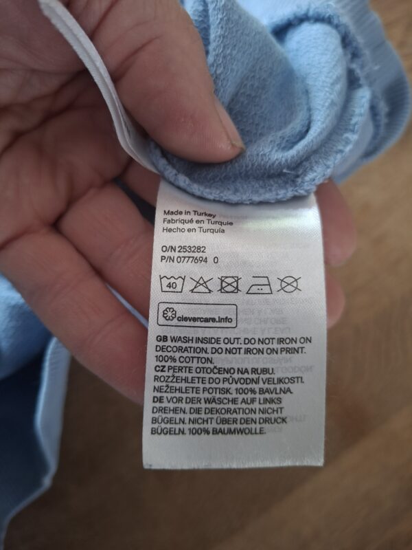20260418_161406 H&M sweater lichtblauw dinosaurus pailletten maat 110/116 nette staat